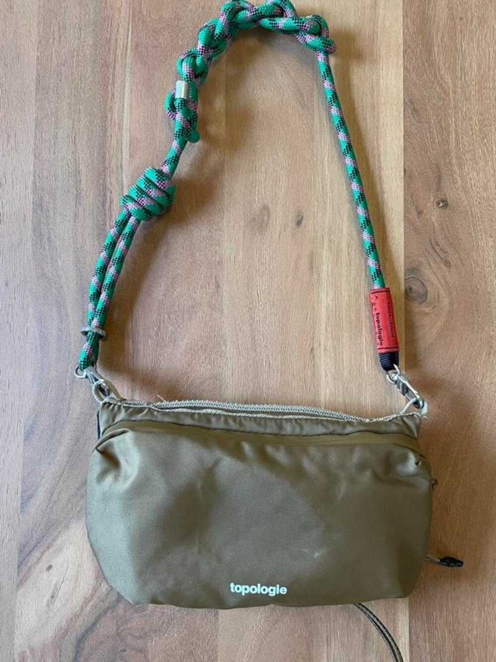 Topologie olive green crossbody bag with adjustable strap.